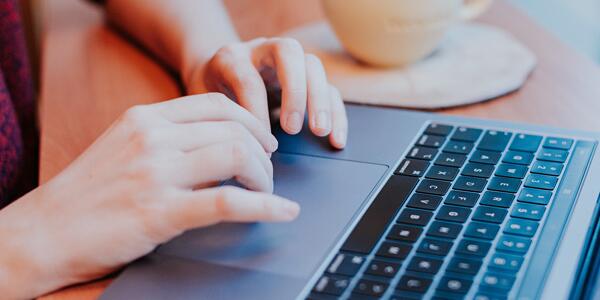 hands typing on laptop keyboard